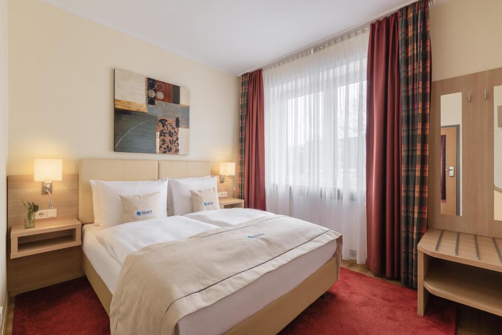 汉堡Select Hotel Tiefenthal的一间卧室设有一张大床和一个窗户。