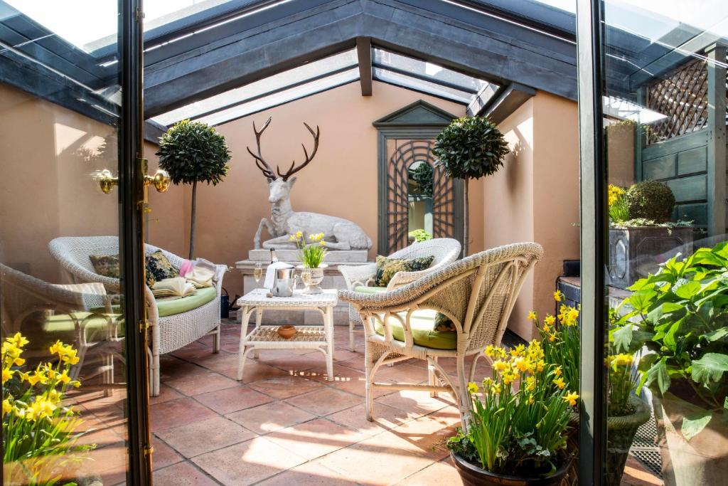 伦敦黑兹利特酒店的庭院配有藤椅和桌子