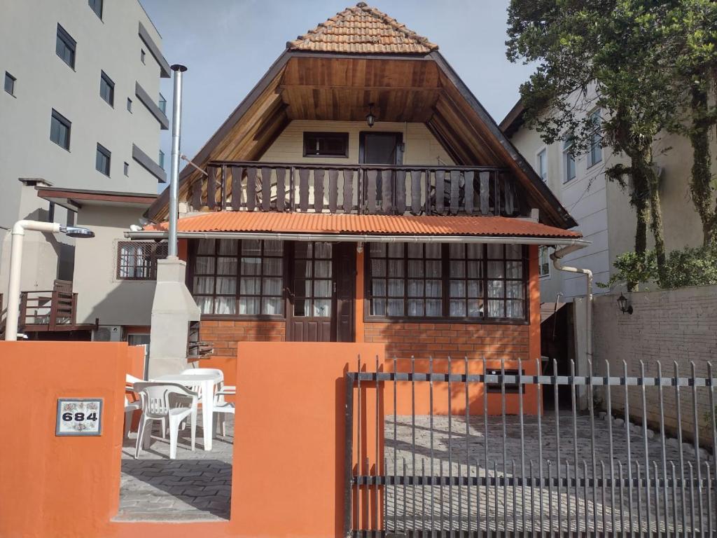 邦比尼亚斯Apartamento estilo chalé - Enxaimel的前面有橙色围栏的房子