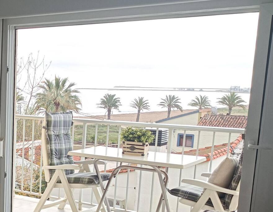 德尼亚Apartamento acogedor en primera linea de playa的阳台配有桌椅,享有海景。