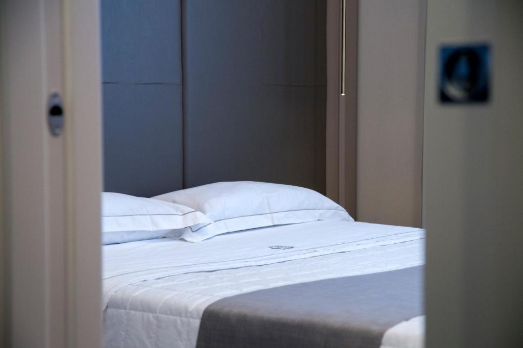 米拉贝拉厄克兰诺Hotel Ristorante Aeclanum的一张配有白色床单和枕头的衣柜