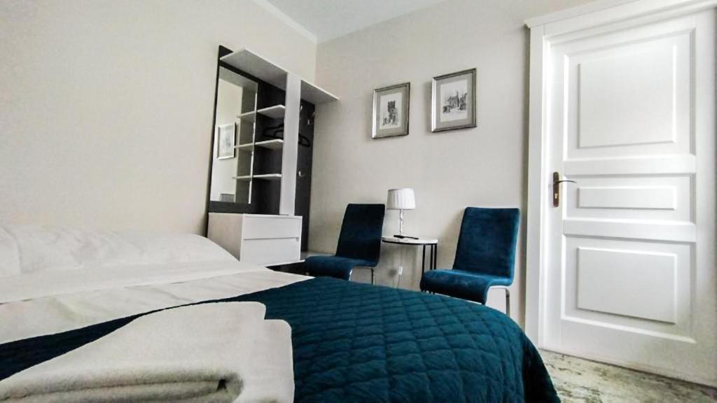 桑多梅日Apartamenty i pokoje gościnne KOŁODZIEJÓWKA的一间卧室配有一张床和两张蓝色椅子