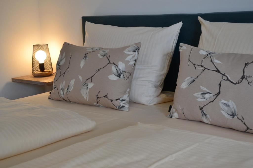 Nieder-Olm克里斯丁花园酒店的一张带两个枕头的床和一盏灯