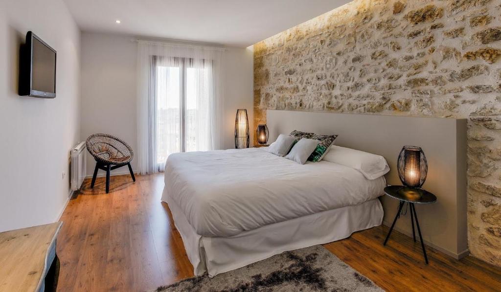 SarratellaHotel Boutique Abadia del Maestrat的一间卧室设有一张大床和石墙