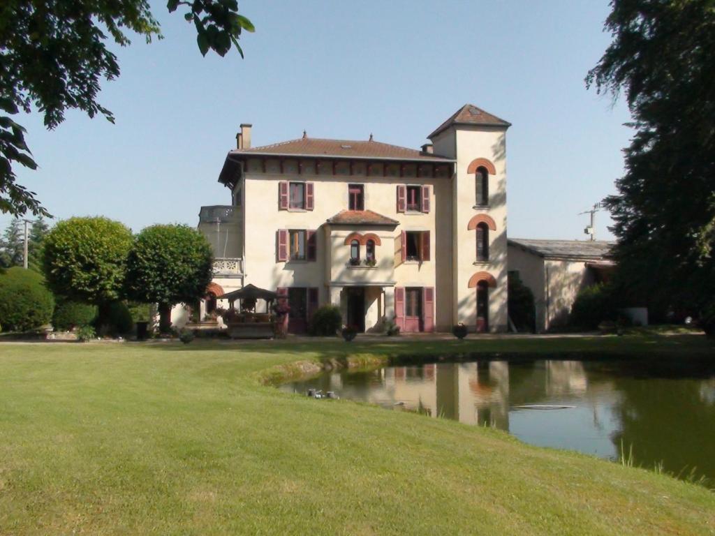 Celles-sur-DurolleDomaine de Marchal - chambres et table d'hôtes的一座老房子,前面有一个池塘