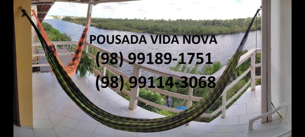 巴雷里尼亚斯Pousada Vida Nova Barreirinhas MA的阳台上的吊床享有水景