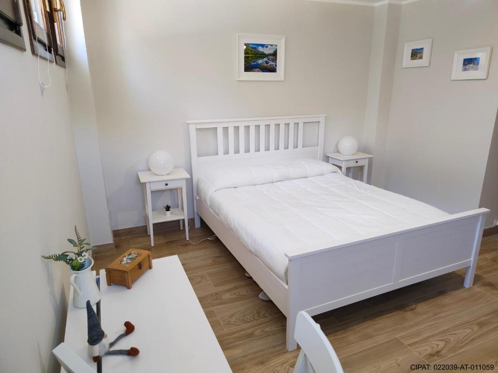 阿尔巴迪卡纳泽伊Pordoi H10的白色卧室配有白色的床和2张桌子