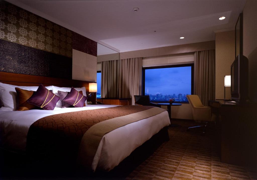 东京东京大都会大饭店的一间设有大床和窗户的酒店客房