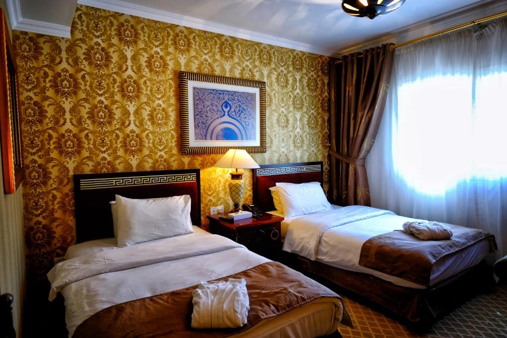 沙迦沙迦国际机场酒店的酒店客房设有两张床和窗户。