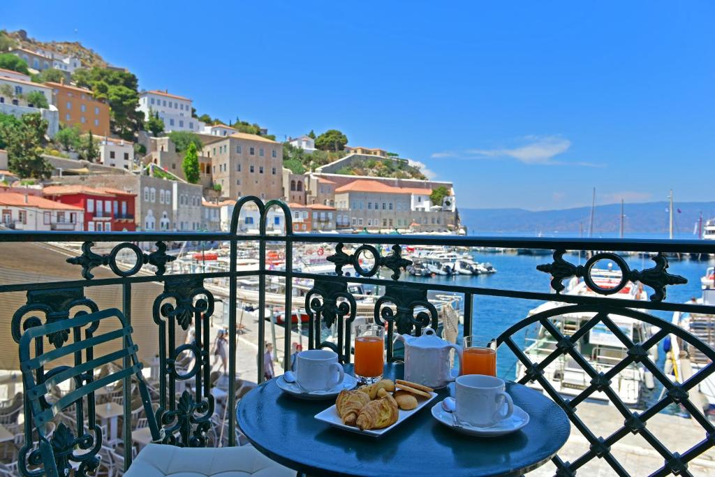 伊兹拉Hotel Sophia的阳台顶部带食物的蓝色桌子