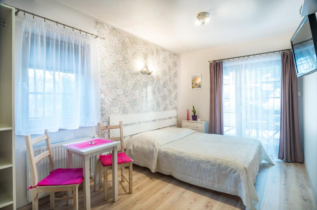 卡齐米日-多尔尼Willa 4 Pory Roku的卧室配有一张床和一张桌子及椅子