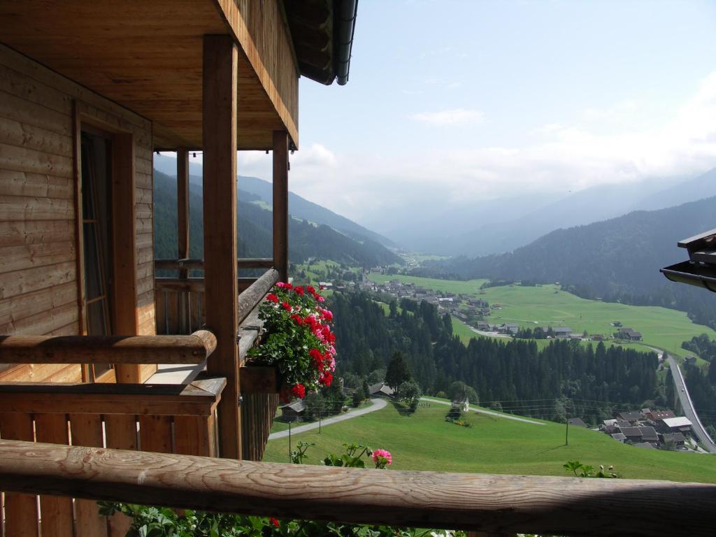Sankt Lorenzen im LesachtalPension Oberhof的从鲜花房子的阳台上欣赏美景
