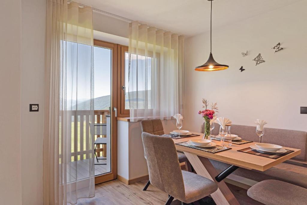 马兰扎Apartment Morgentau的一间带桌椅的用餐室和一个阳台