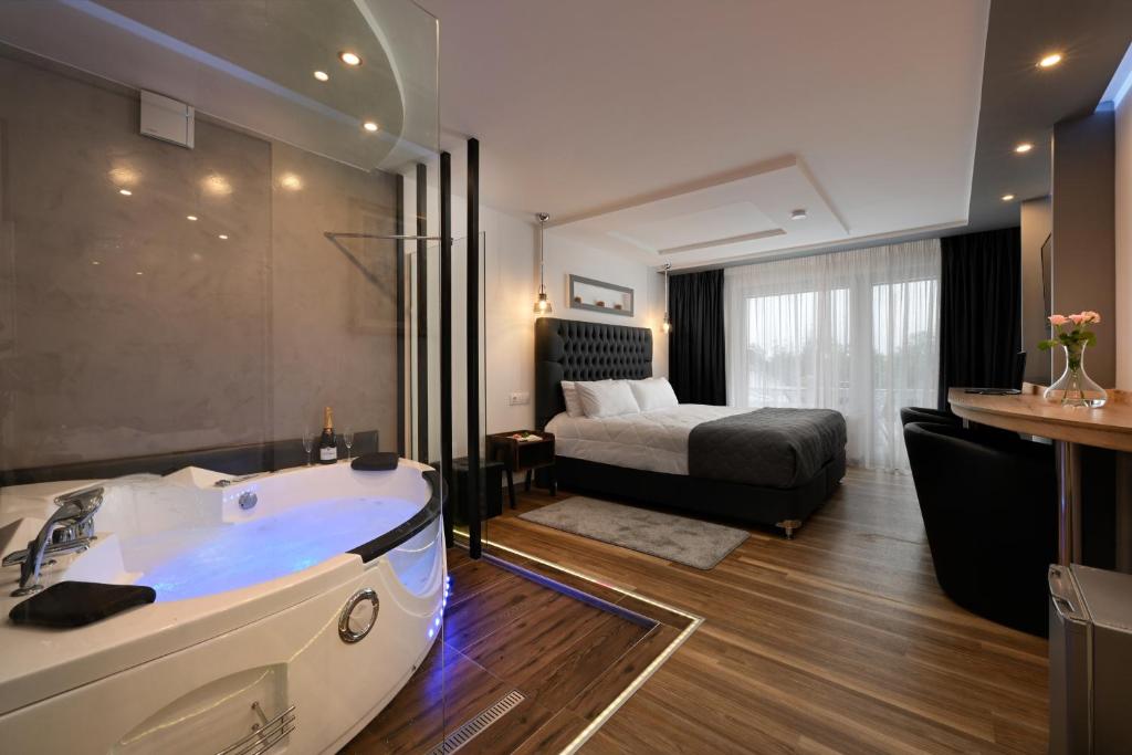 圣安德里斯伯格Angelo Spa Resort的带浴缸和床的浴室