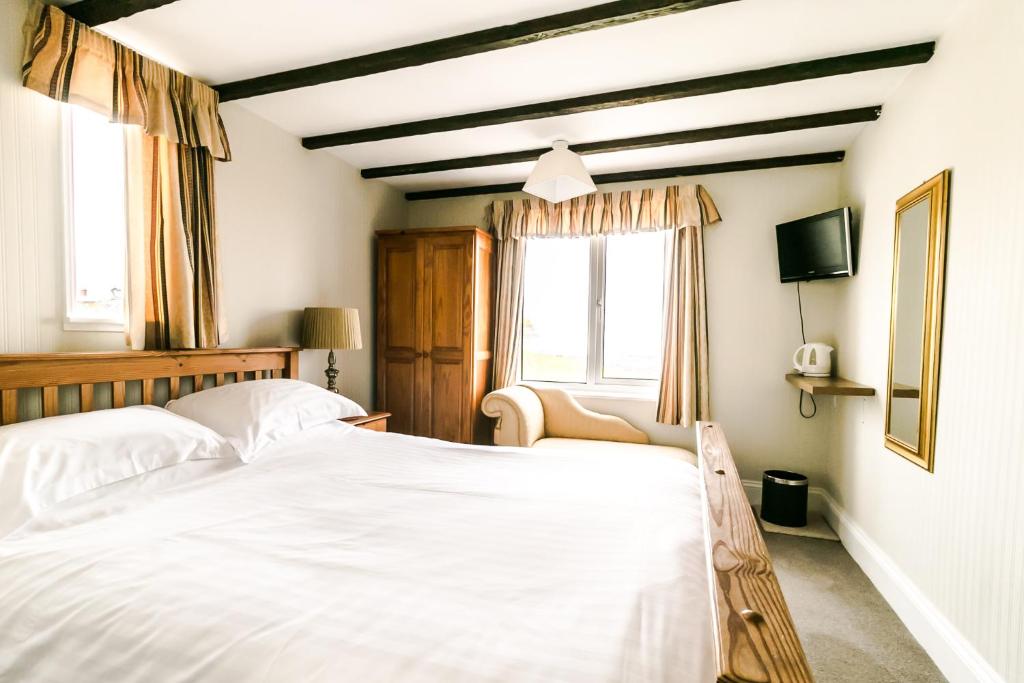 布里克瑟姆Raddicombe Lodge的卧室配有白色的床和窗户。