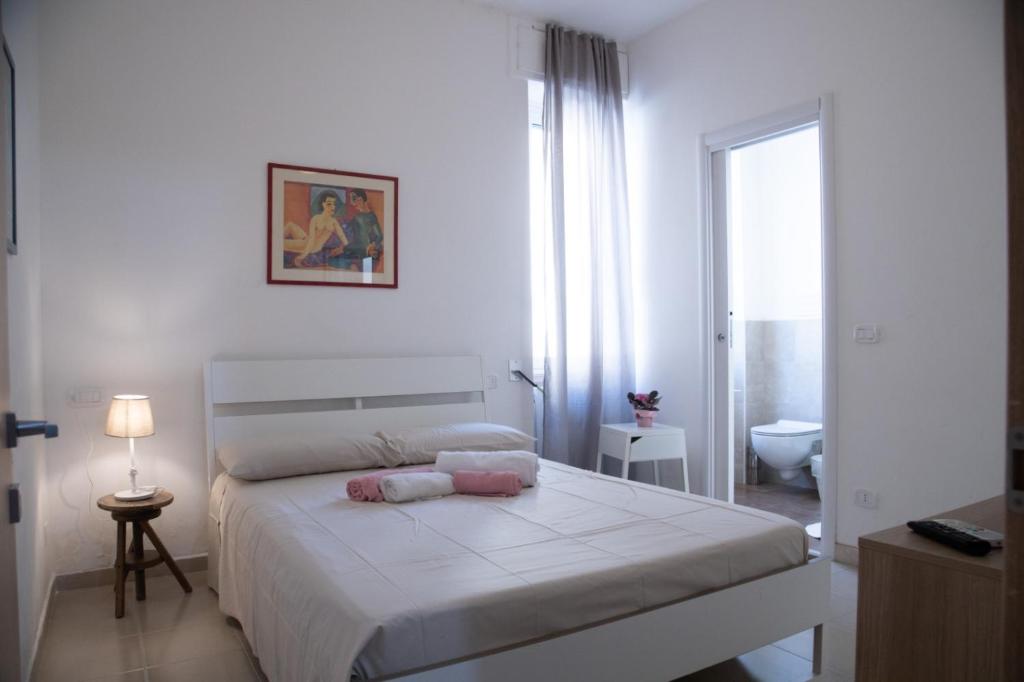 孔韦尔萨诺La Vispa Teresa zona ospedale的一间白色卧室,配有床和一间浴室
