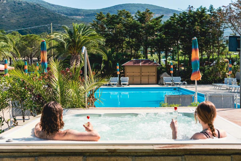 拉科纳Casa Dei Prati Camping Village的两人坐在游泳池里