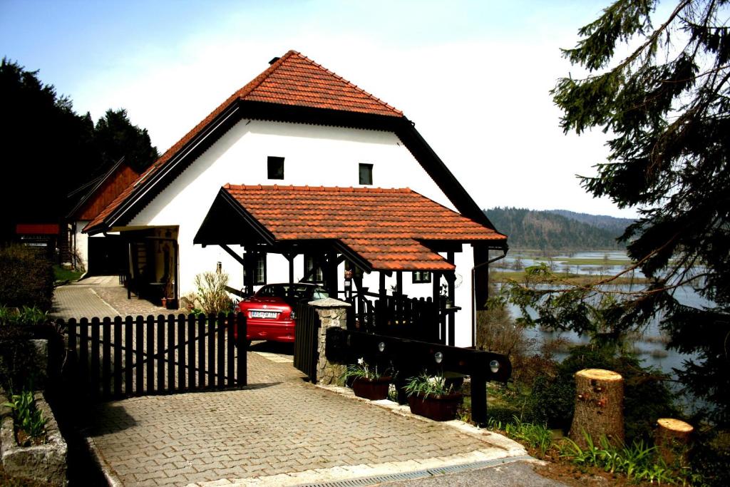PlaninaApartment Šefic的白色的房子,有红色的屋顶和栅栏