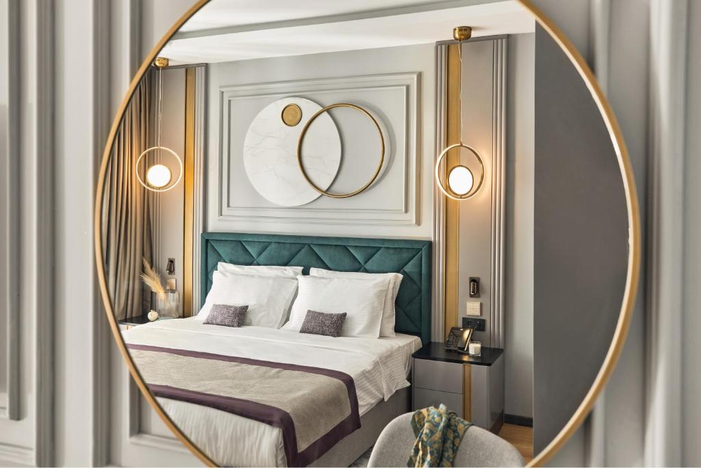 蒂瓦特La Fleur Boutique Hotel的一间卧室配有一张带金框和镜子的床