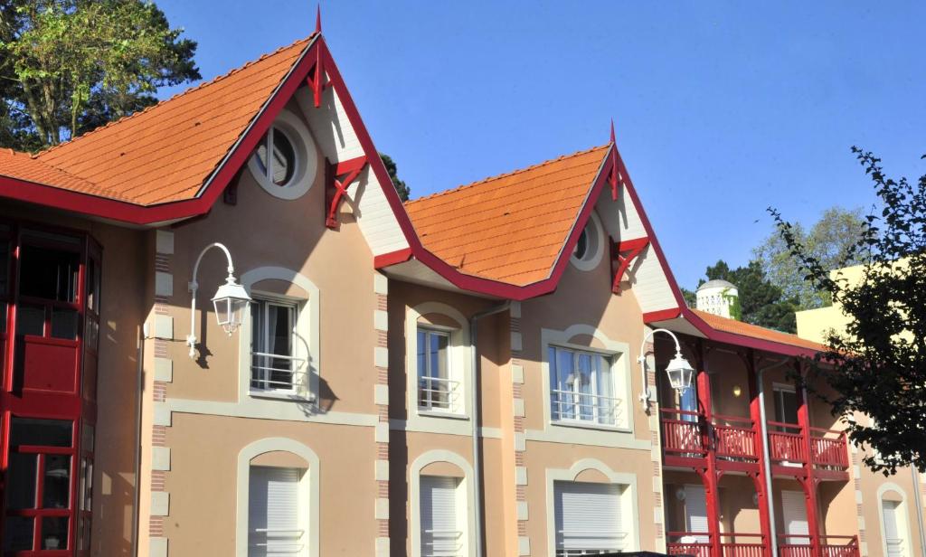 阿卡雄Lagrange Vacances - Résidence Jardin Mauresque的一座带橙色屋顶的大型建筑