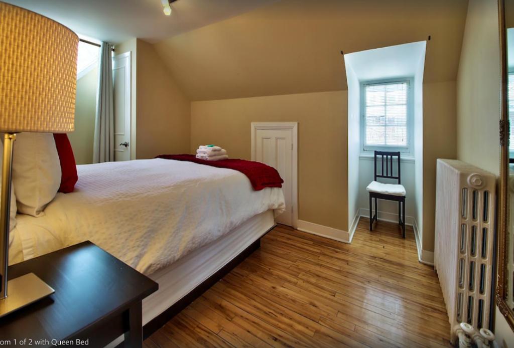 魁北克市莱斯曼蒙卡姆公寓的一间卧室配有一张床、一张桌子和一个窗户。