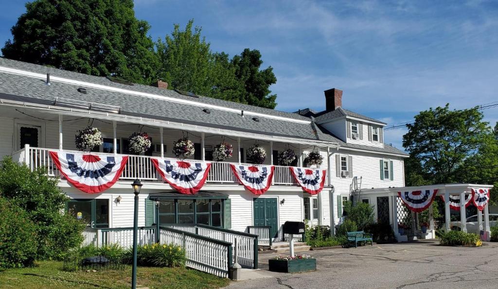 沃尔夫伯勒Windrifter Resort的一座白色的房子,上面悬挂着美国国旗