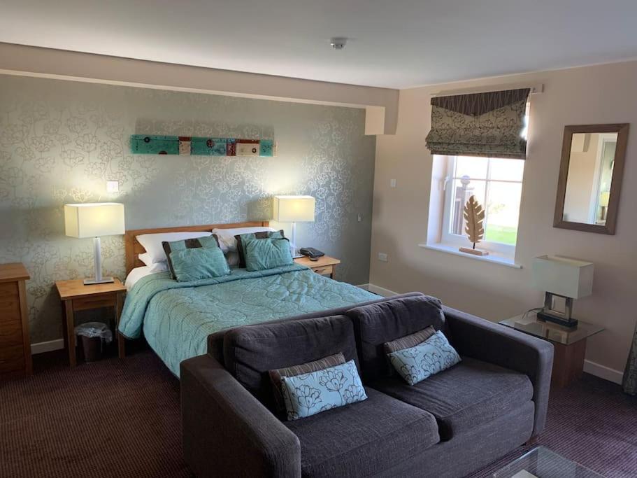 彭里斯Ullswater Suite的一间大卧室,配有一张床和一张沙发