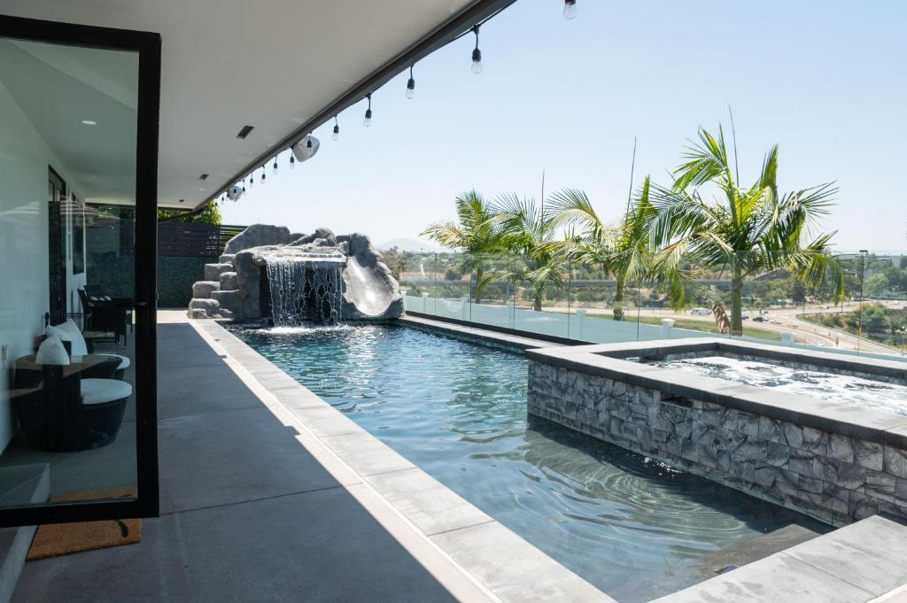 圣地亚哥New Modern Luxury Estate - Pool, Slide, Grotto的一座房子里一个带瀑布的游泳池
