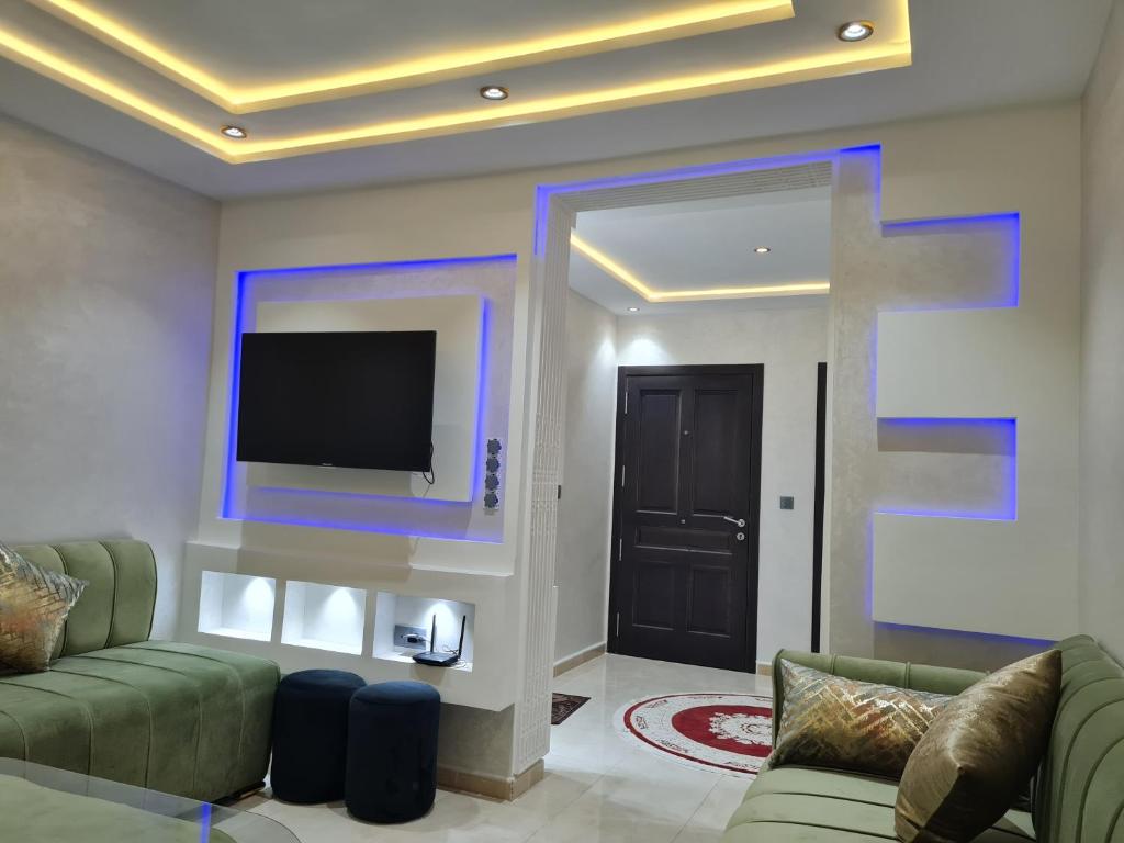 纳祖尔Appartement a Nador的客厅配有沙发和墙上的电视
