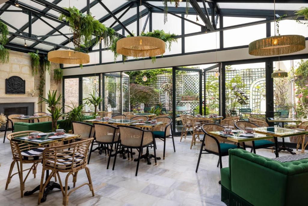 巴黎贝尔纳酒店的餐厅设有桌椅和窗户。