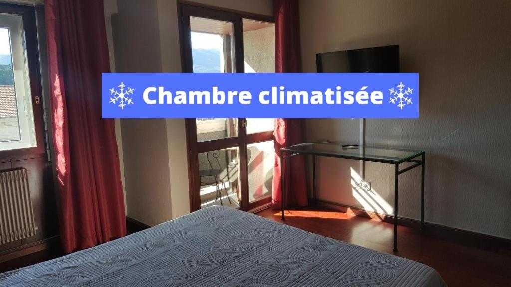 艾克斯莱班车站酒店的一间卧室配有一张床和一个可读气候温度信号的标志
