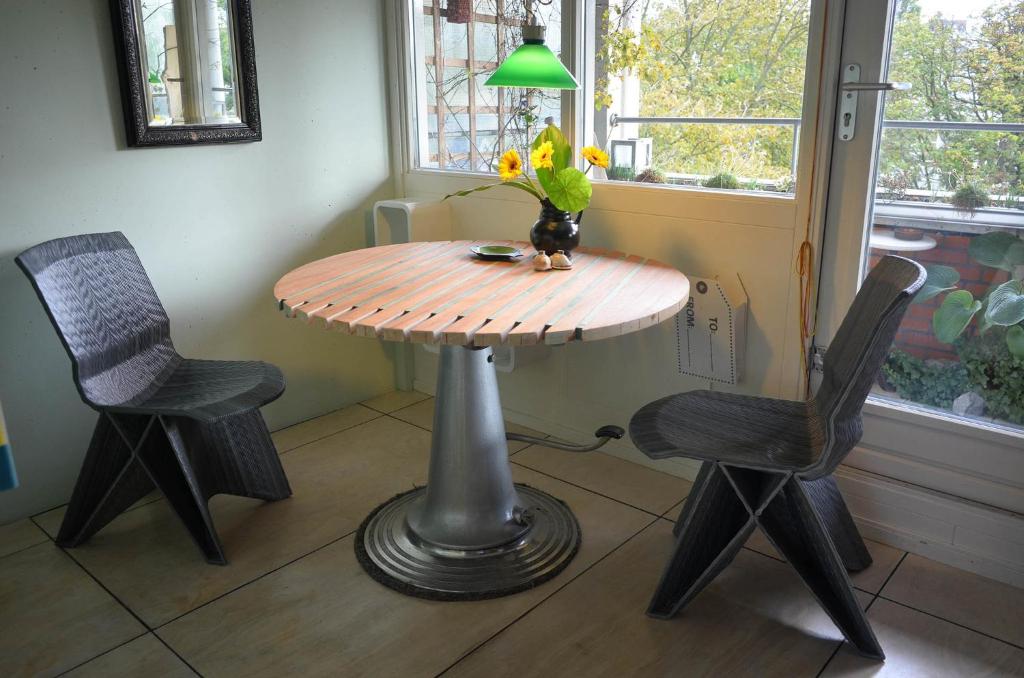 海牙树顶公寓的一张桌子、两把椅子和一个花瓶