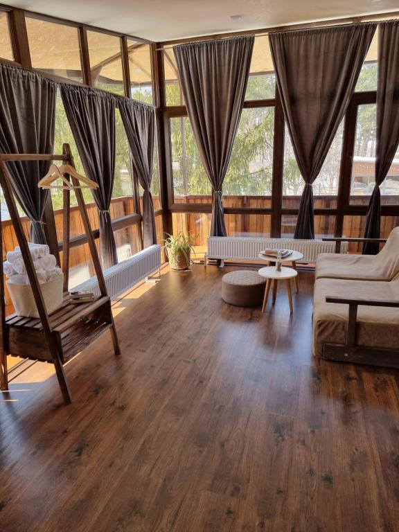 斯捷潘纳万EcoLife Lodge Hotel & Restaurant的大型客厅铺有木地板,设有窗户。