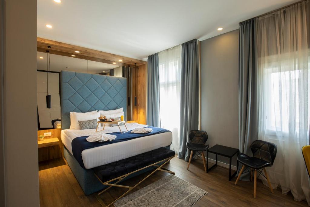 贝尔格莱德Nobel Gallery Hotel的一间卧室配有一张大床和蓝色床头板