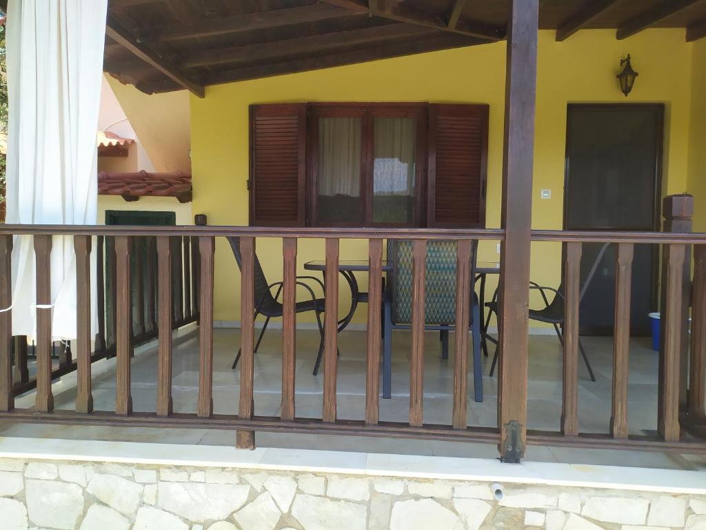 奥马斯帕纳吉亚斯Ioannis Stagkonis House 1的阳台设有椅子和黄色墙壁