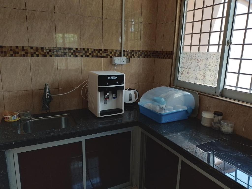 阿罗士打Rahman Homestay Pantai Johor - ISLAM SAHAJA的厨房配有水槽和台面上的咖啡壶