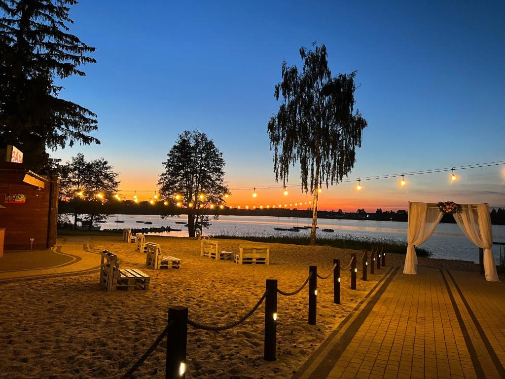 奥克宁卡Hotel Sanvit Lake Resort & Spa的海滩上设有桌椅和一串灯光