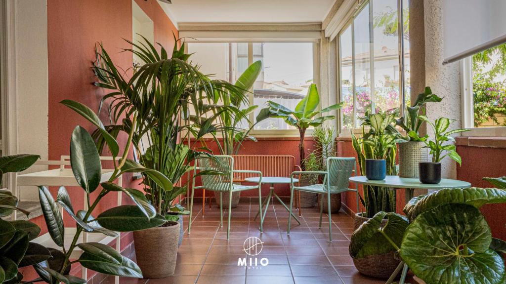 圣温琴佐MIIO HOTEL的一间布满植物的房间,桌子和椅子