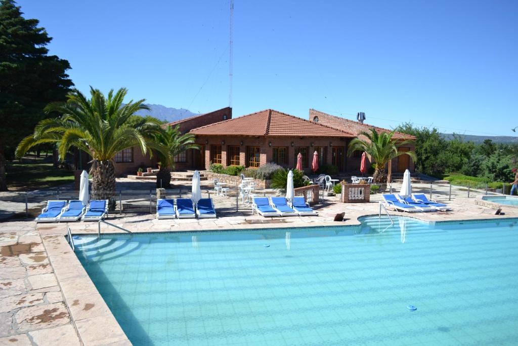 米娜克拉韦罗Colina del Valle的一个带蓝色椅子的游泳池