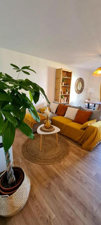 蒙彼利埃Appartement avec terrasse, parking et proche tramway的客厅配有黄色沙发和植物