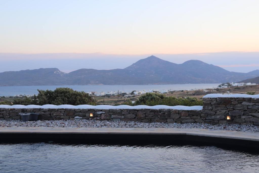 阿达玛斯Valeria's House的一座带石墙和山脉背景的游泳池