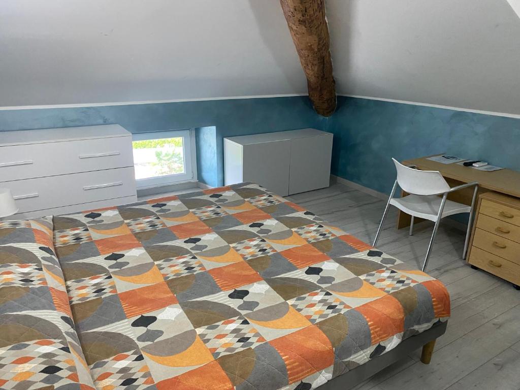 CadenazzoPluto Centrale的一间卧室配有一张床、一张桌子和一把椅子
