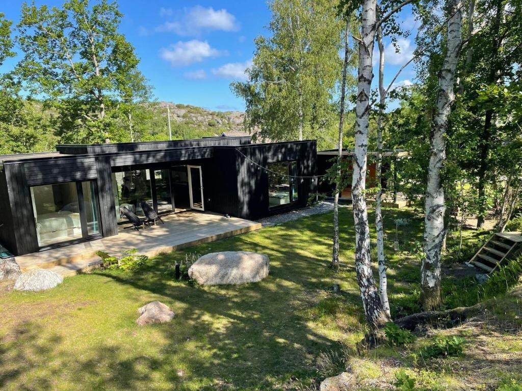 HälleviksstrandHoliday home HÄLLEVIKSSTRAND V的树林中的黑色房子