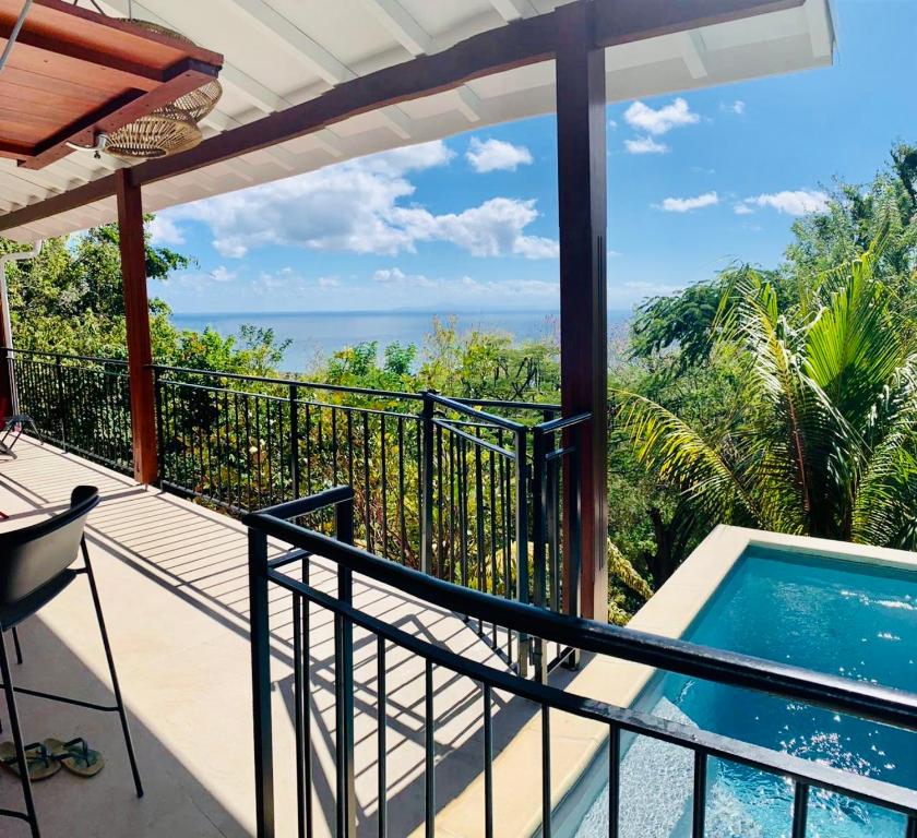圣吕斯Magnifique Villa Bauhinia, Piscine vue mer的阳台享有游泳池和海洋的景致。