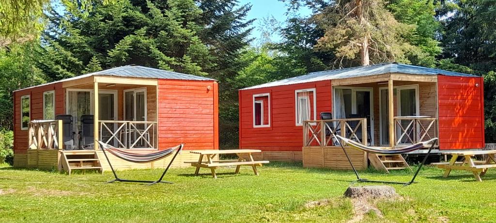 CamuracChalet et mobil homes dans la montagne au Camping les Sapins的两栋小房子,在院子里设有吊床
