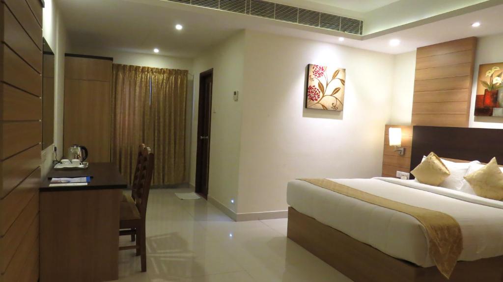 特里凡得琅Hotel Rajadhani的一间卧室配有一张床和一张书桌