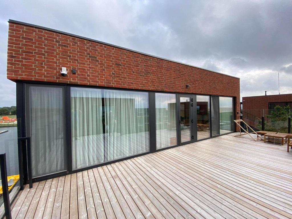 SvencelėApartamentai Svencele的木甲板上设有滑动玻璃门的建筑