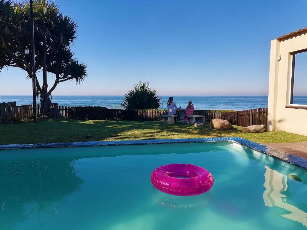 马盖特Southern Comfort - On the Pool的游泳池里有一个粉红色的飞盘