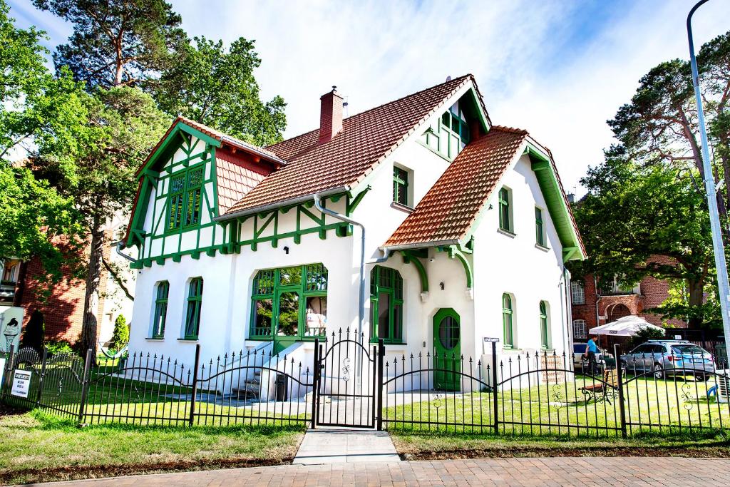 库瑞尼卡慕斯卡Willa Kryniczanka的白色房子,有红色屋顶