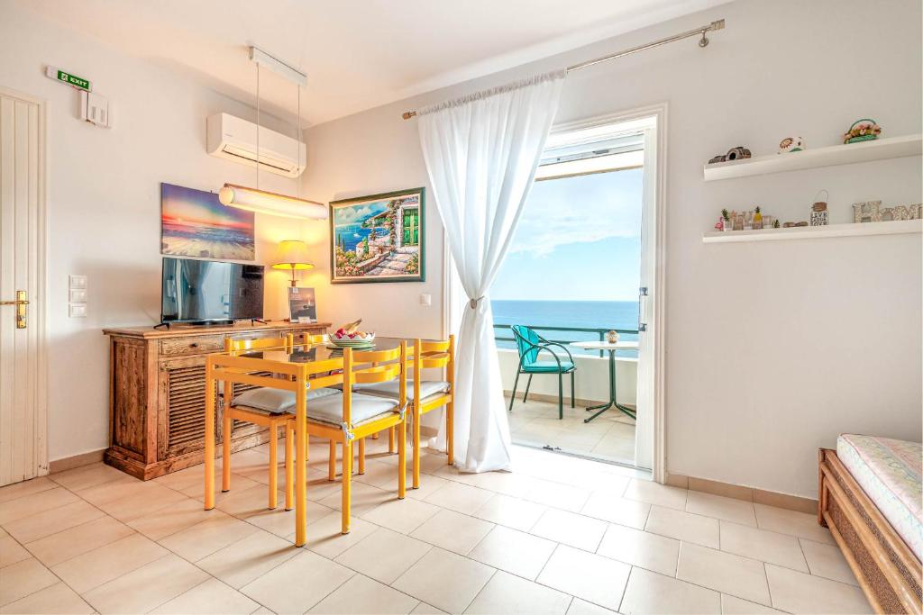 格利法达Glyfada New Era Home 107 Menigos Resort Apartments的客厅设有餐桌,享有海景。